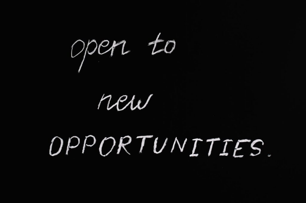 Blackboard with motivational quote 'Open to New Opportunities' in chalk writing.